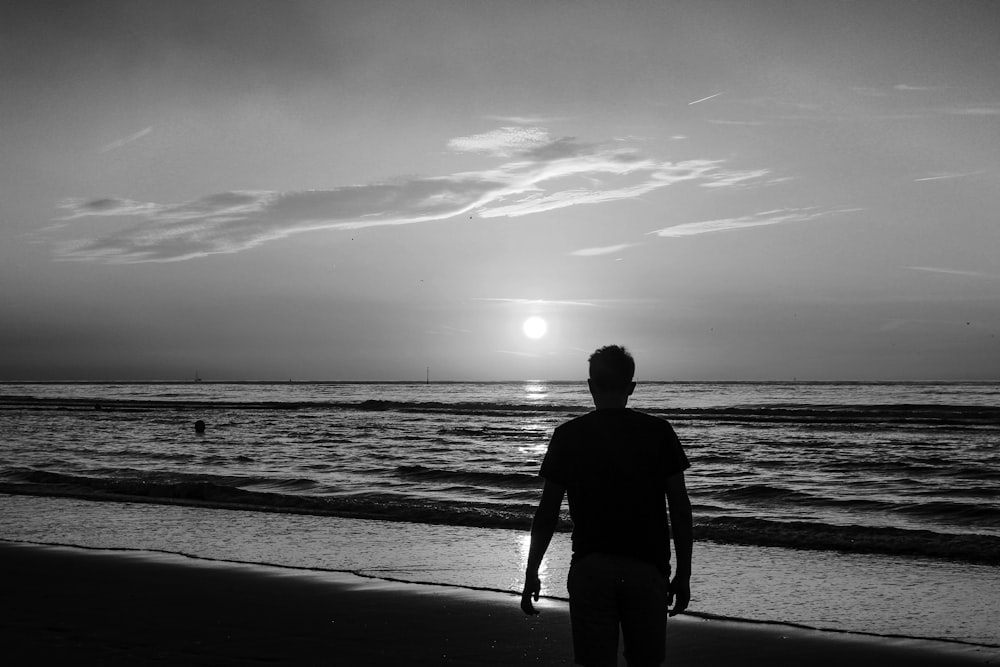 silhouette of man walking on beach during daytime