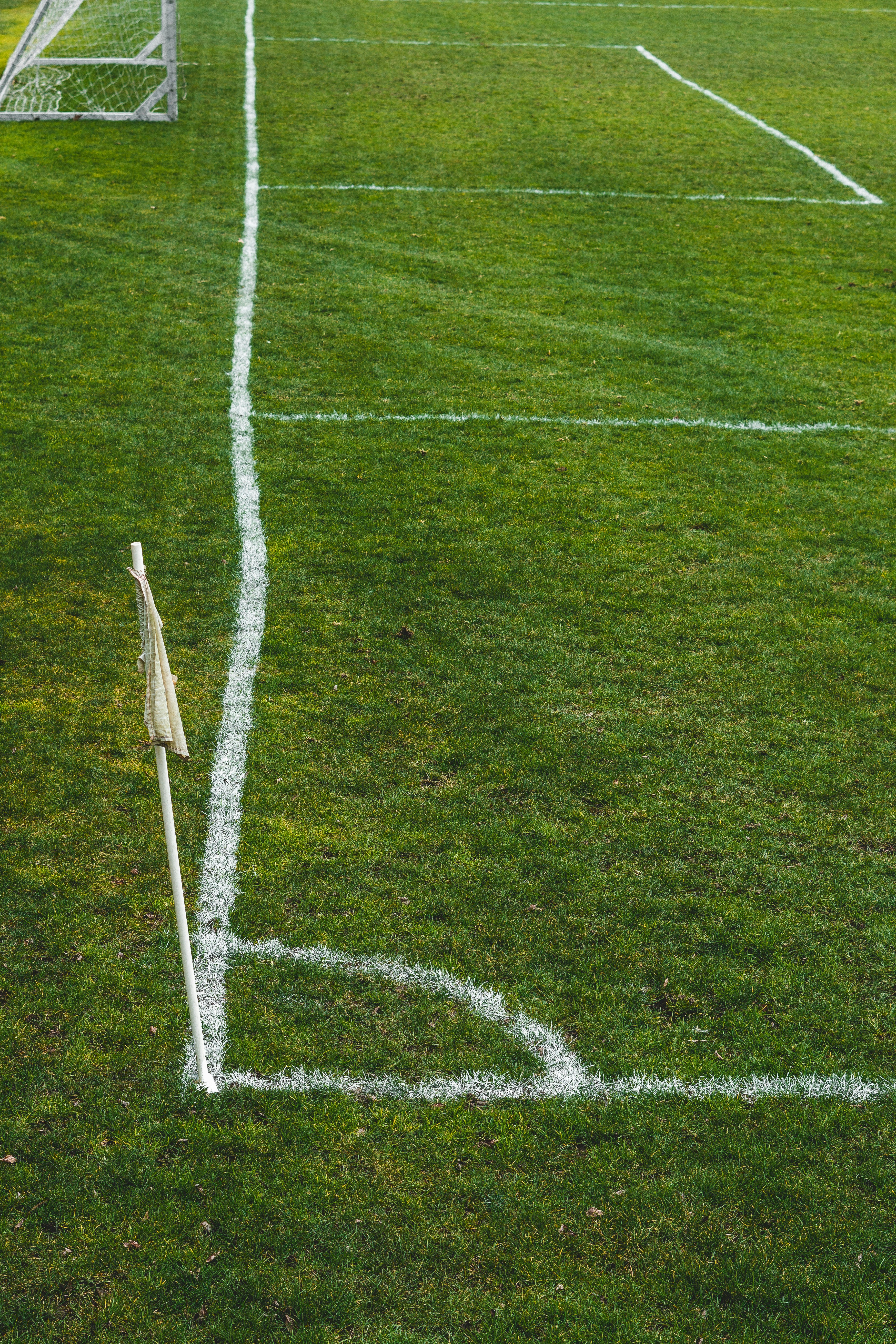 white and black soccer goal on green grass field