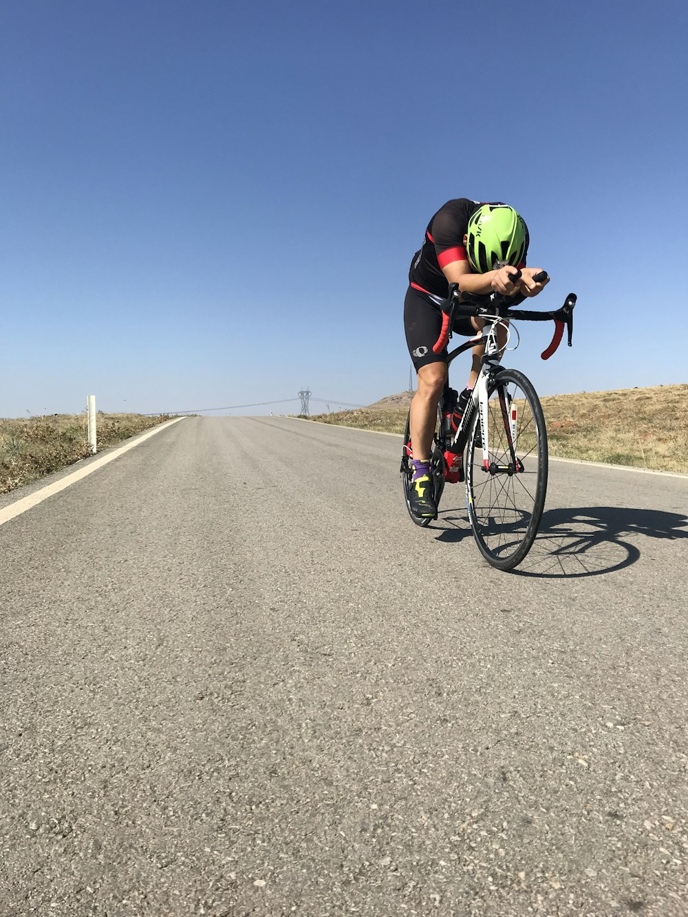 man in green shirt riding bicycle on road during daytime