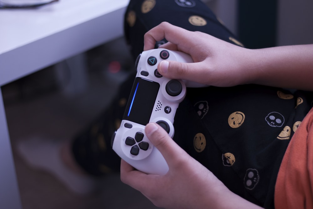 person holding white sony ps 4 controller