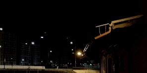 Nighttime shot of a roof repair illuminated by portable work lights.