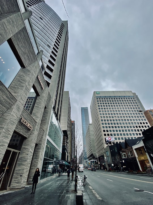 cars on road between high rise buildings during daytime in Bloor Street West Canada