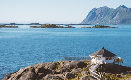 white and brown concrete house near body of water during daytime in Hamn i Senja Norway