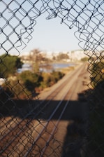 brown field with gray chain link fence during daytime