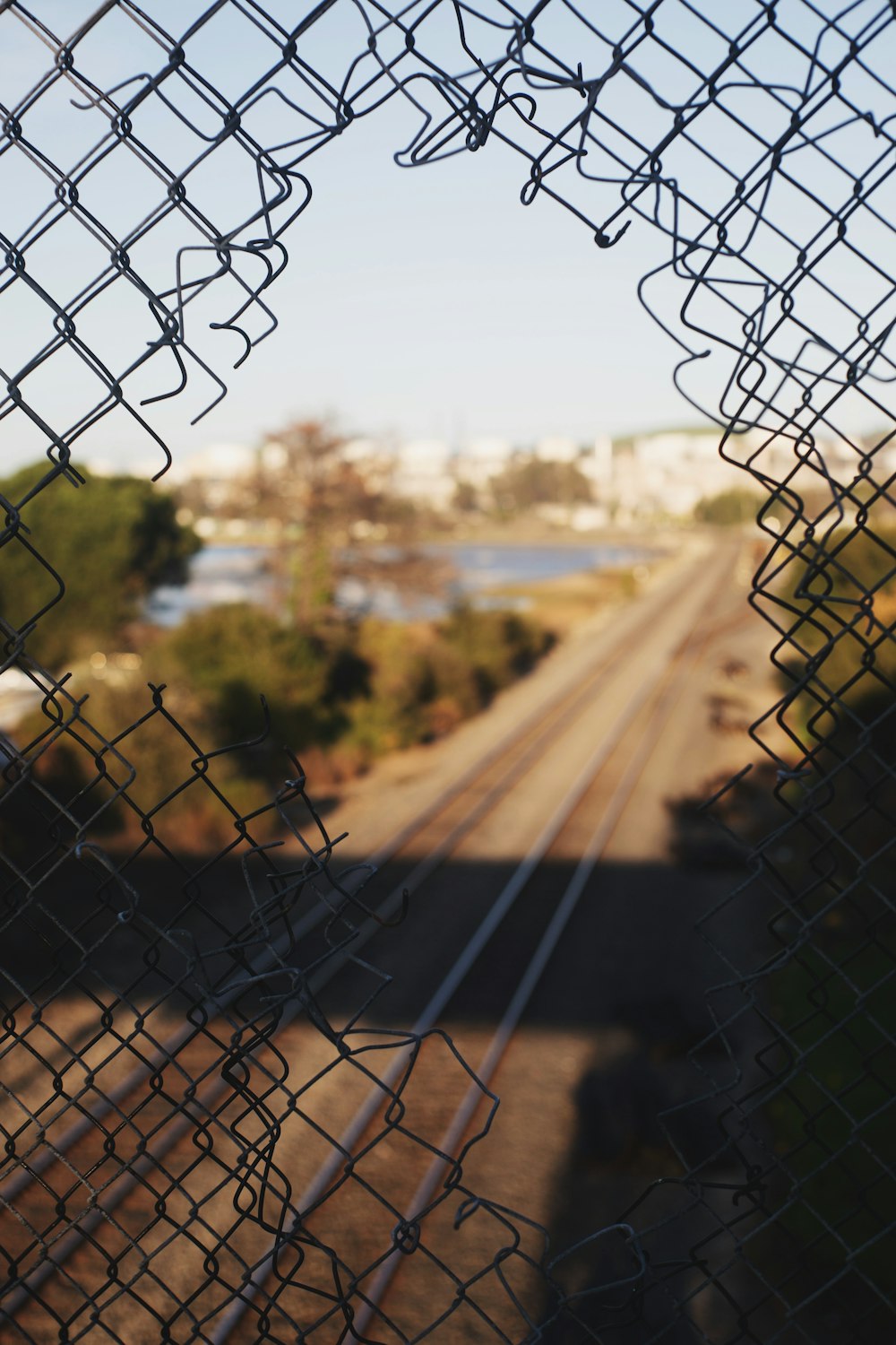 campo marrone con recinzione grigia del collegamento della catena durante il giorno