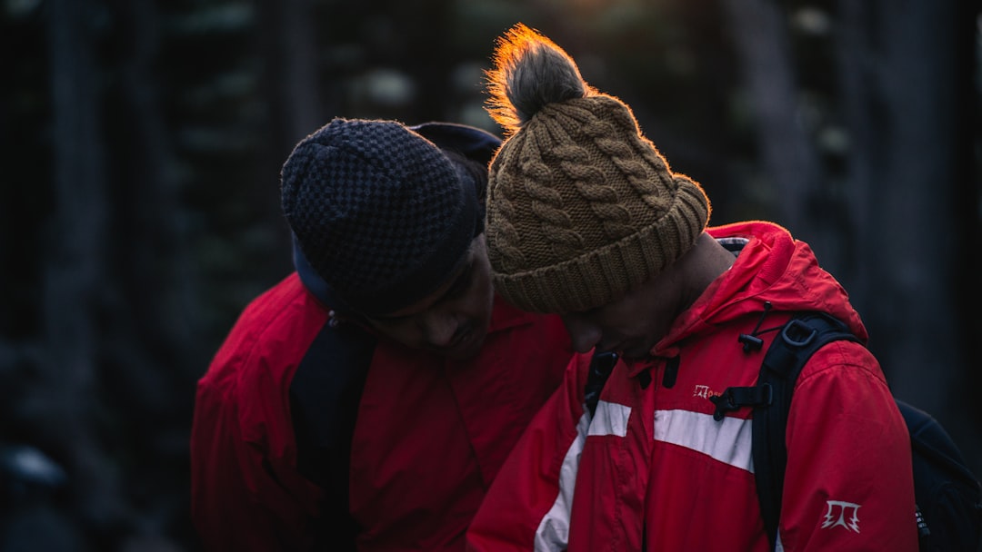 man in red jacket wearing brown knit cap