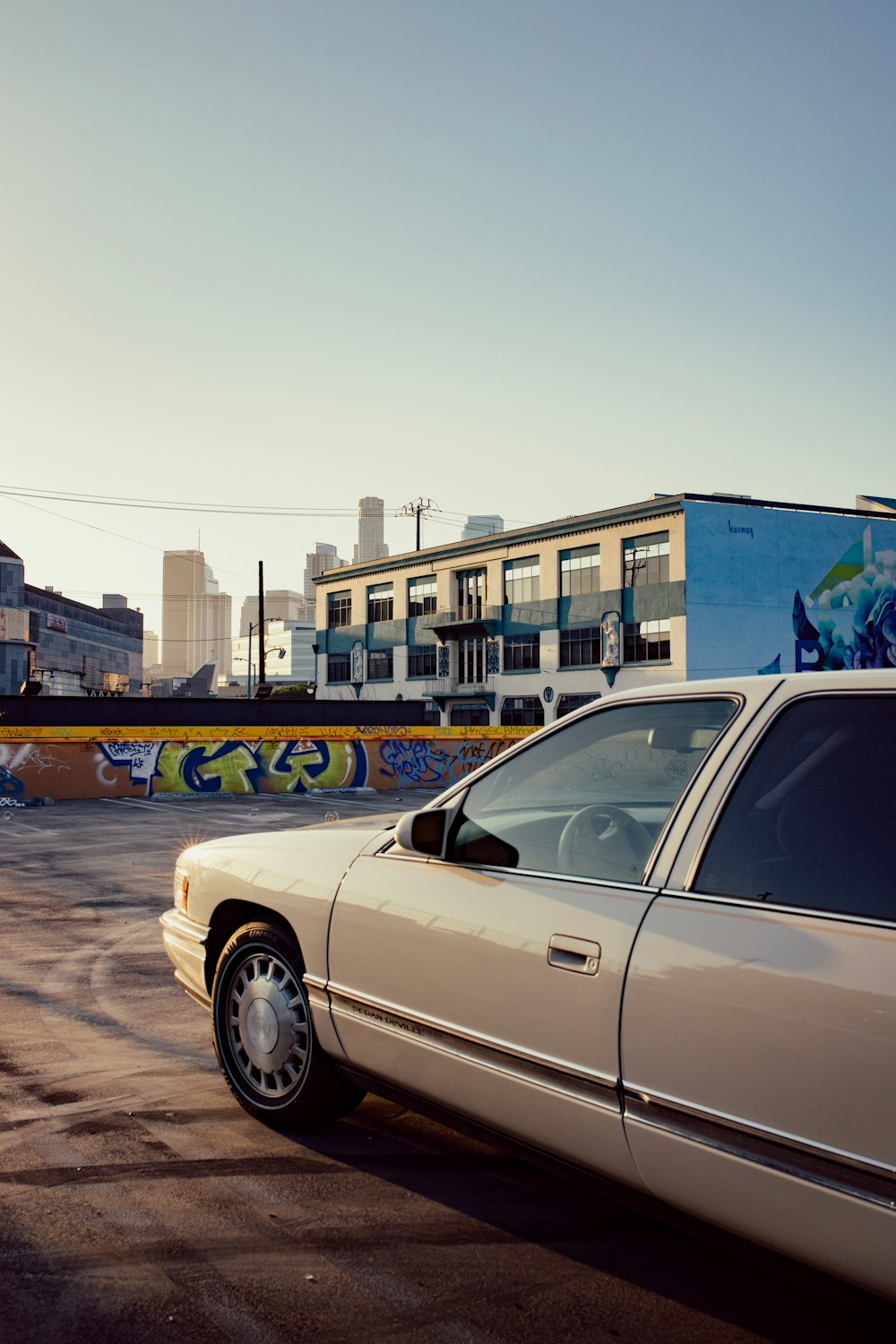 white sedan parked near blue building during daytime