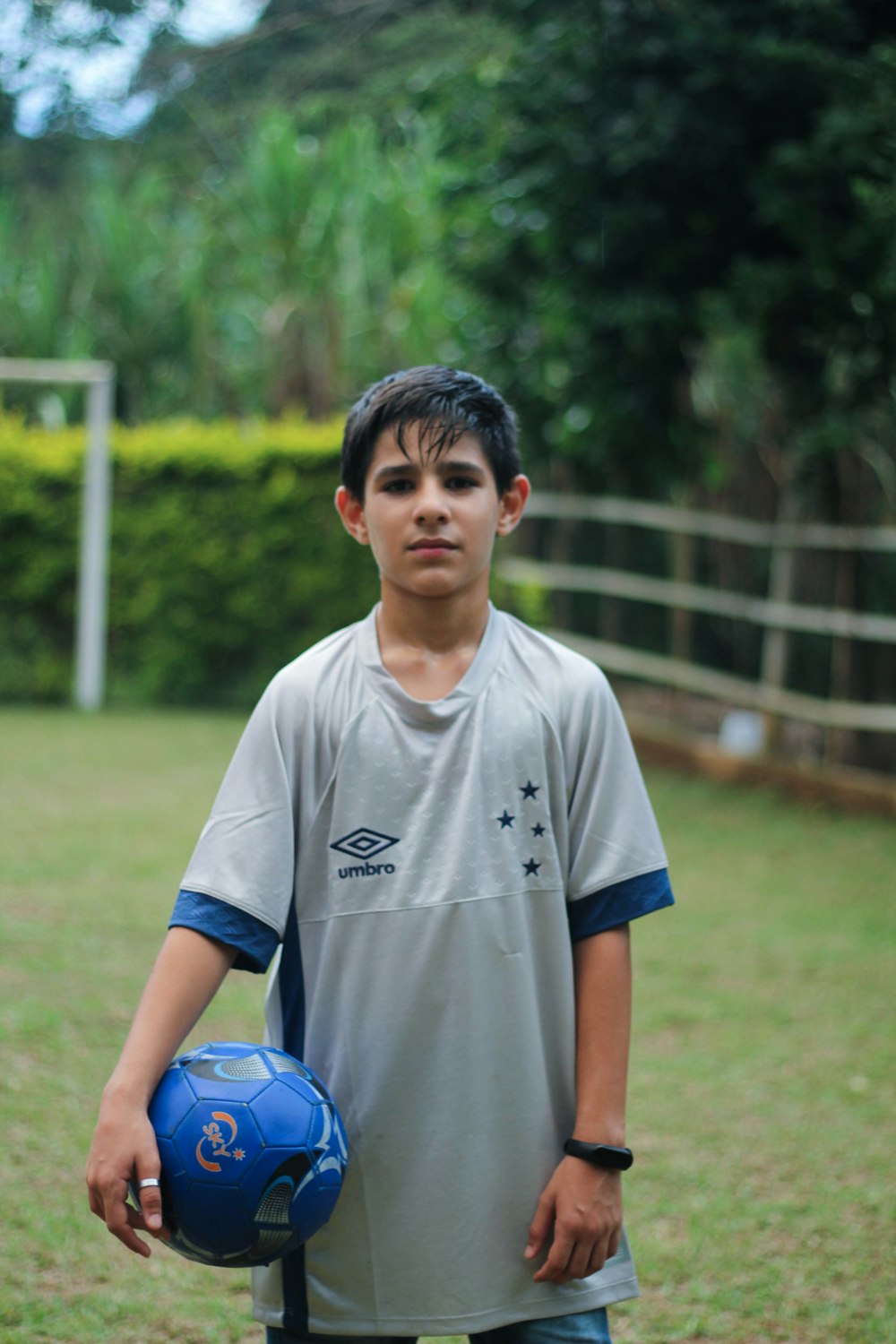 boy in white crew neck t-shirt standing on green grass field during daytime