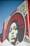A large mural on a brick wall features a striking black-and-white portrait of a woman surrounded by bold red typography. The words 'Power & Equality' and 'Power to the People' are prominently displayed. Decorative patterns frame the portrait, adding artistic flair to the composition.