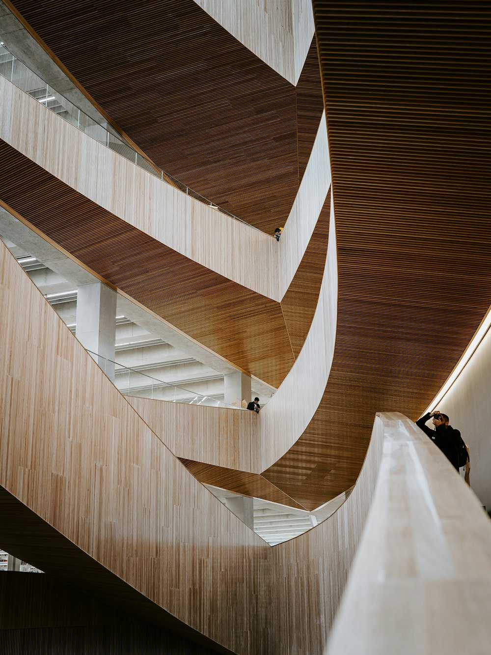 man in black jacket walking on white spiral staircase