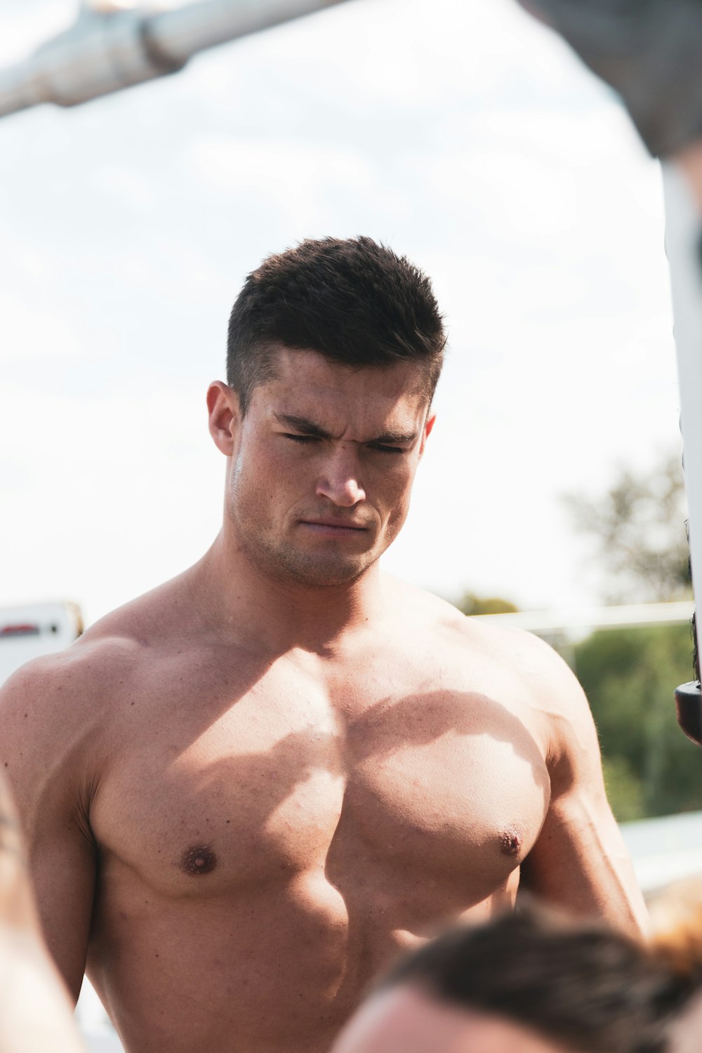 topless man standing near green trees during daytime