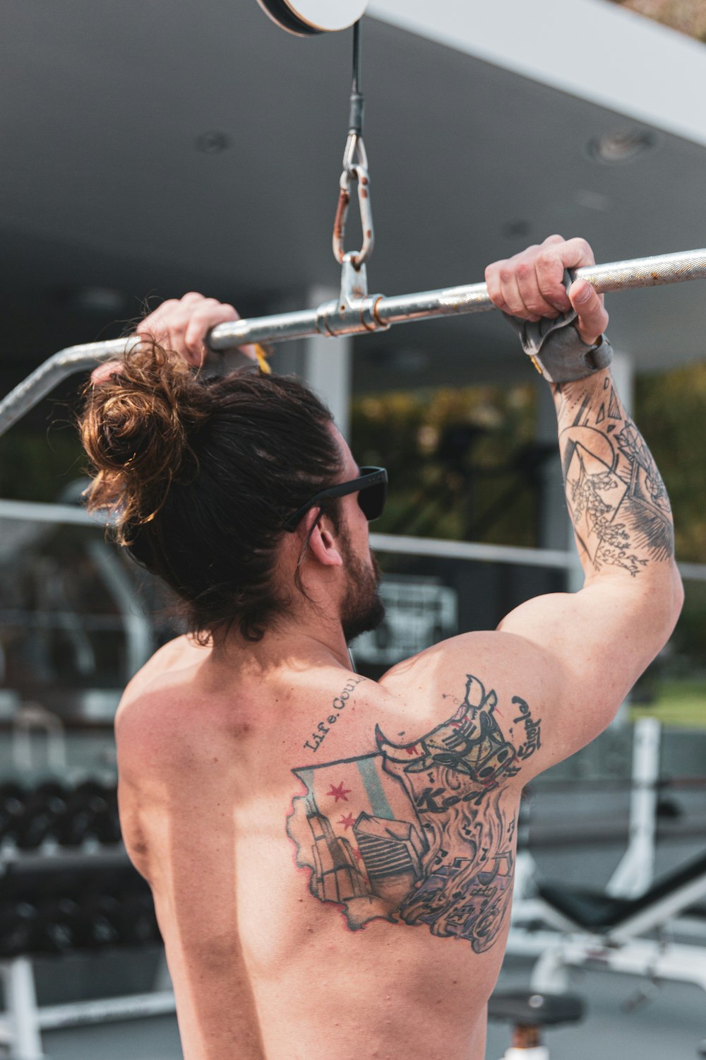topless man with black tattoo on his back