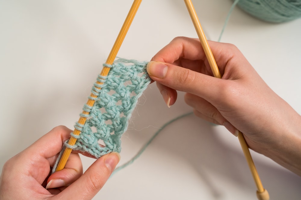 person holding blue and white yarn