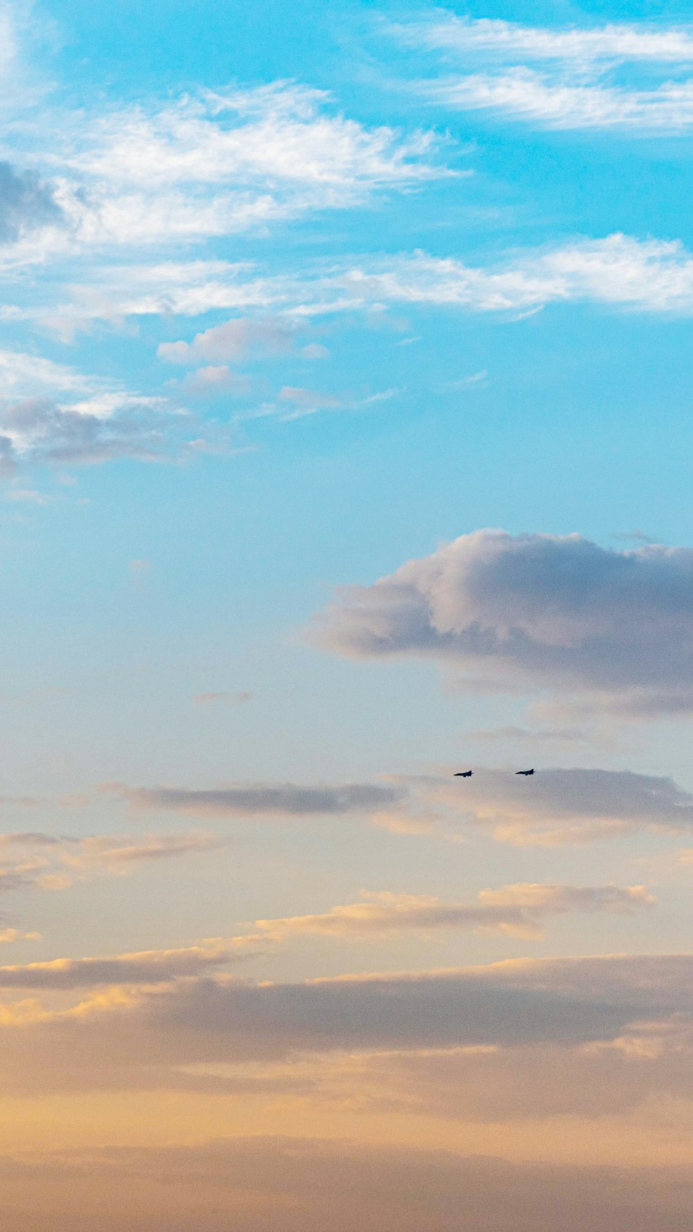 昼間に白い雲の上を飛ぶ飛行機の写真 Unsplashの無料写真