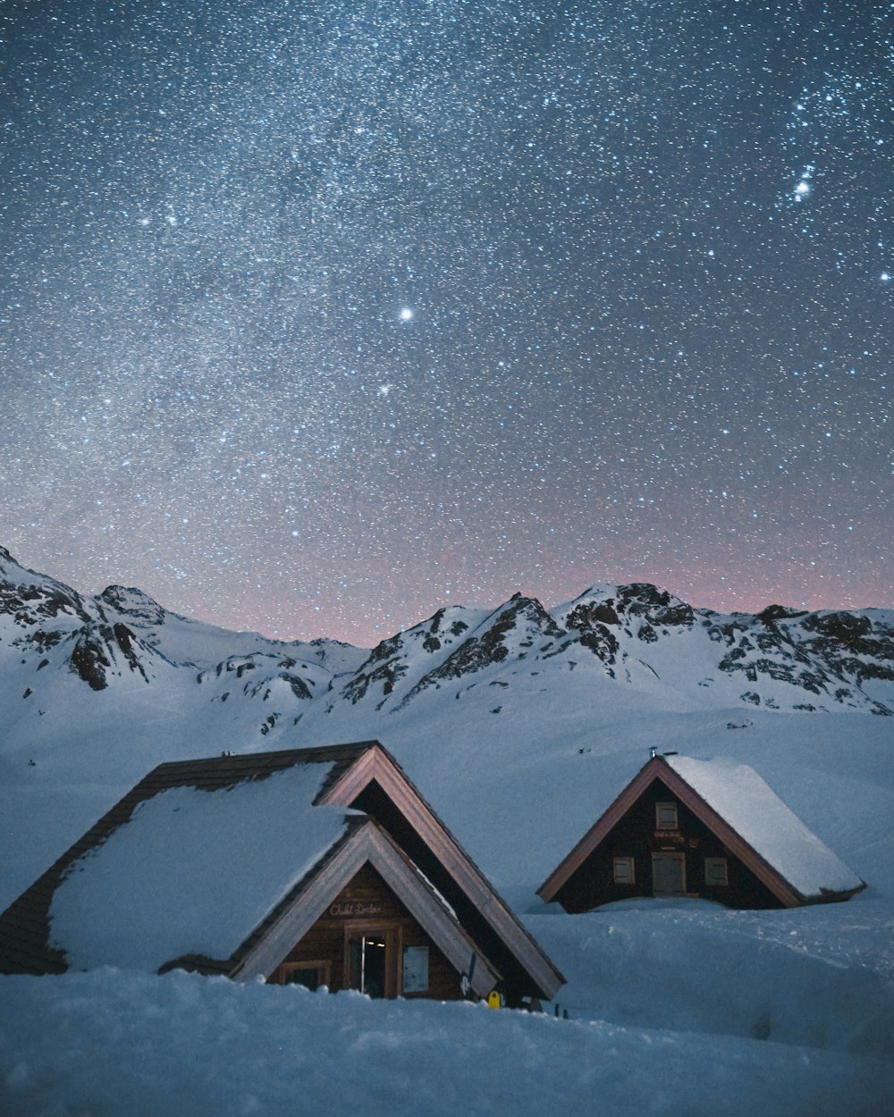brown wooden house on snow covered ground during night time