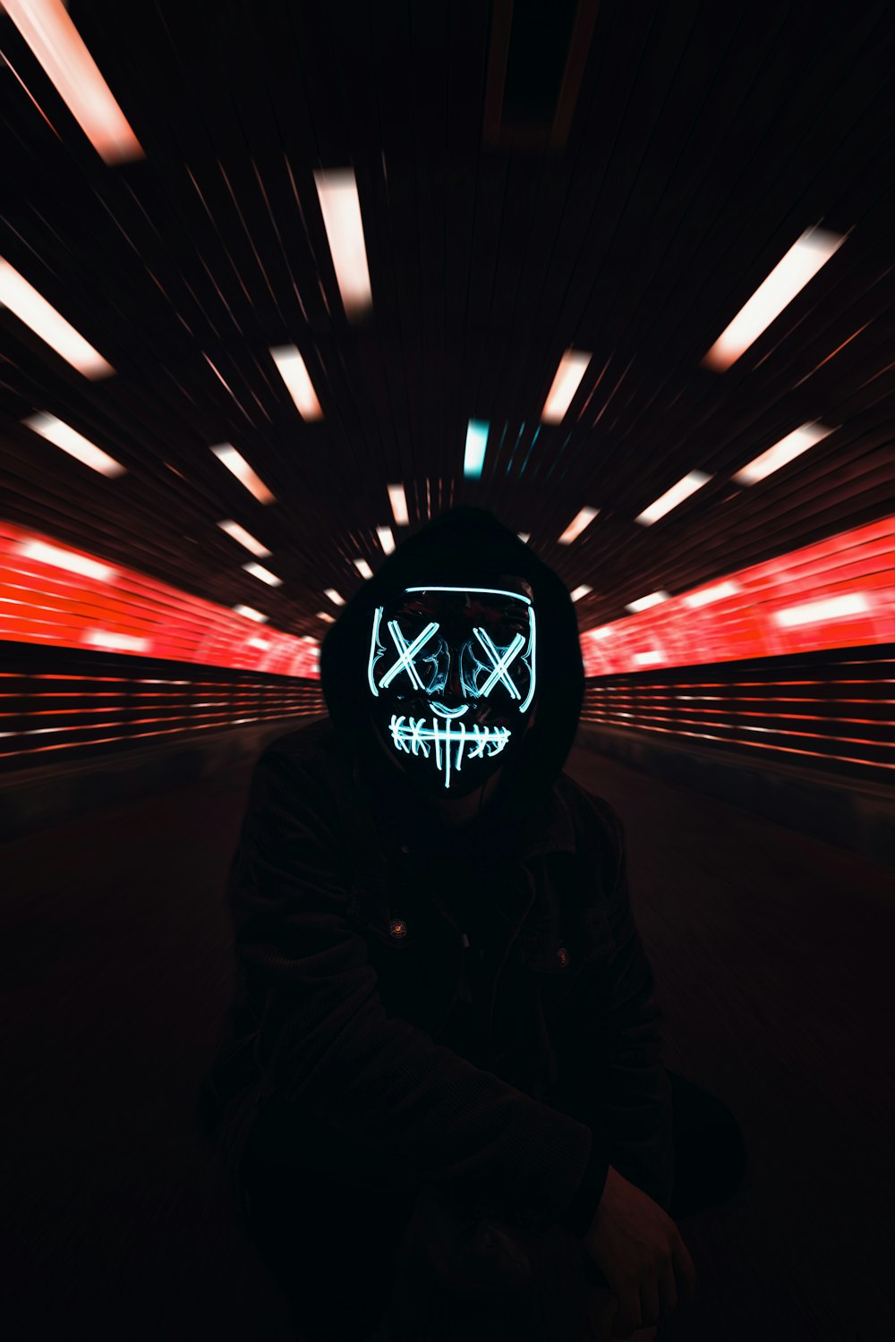 man in black hoodie standing in tunnel