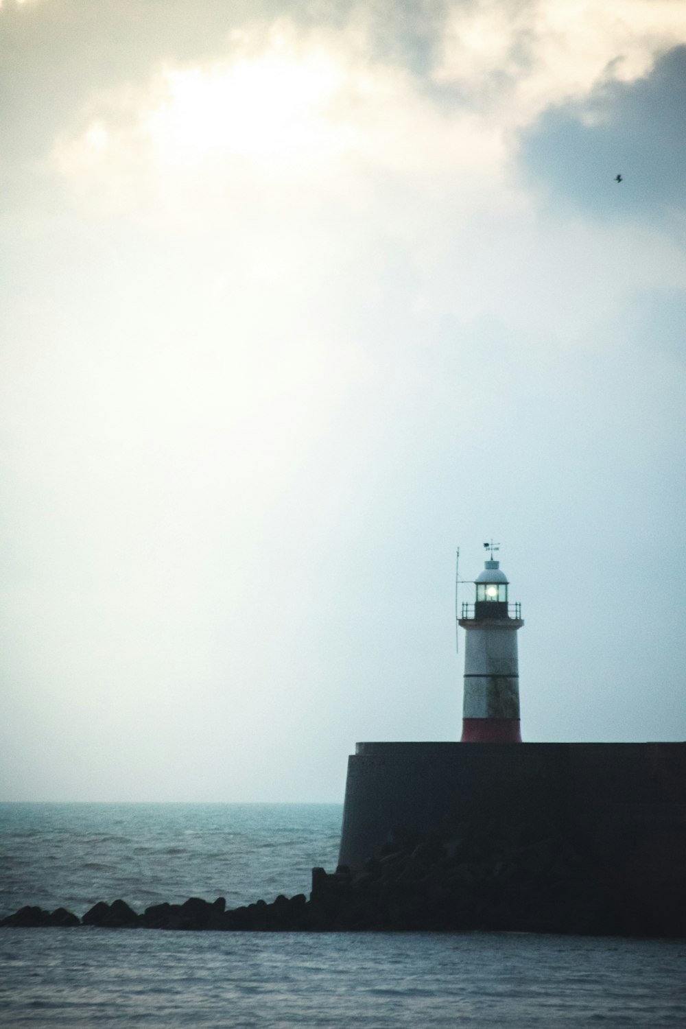 white and red lighthouse on the sea
