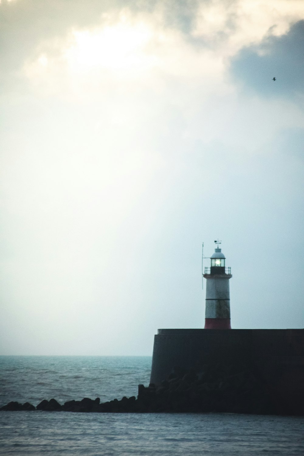 Weißer und roter Leuchtturm am Meer