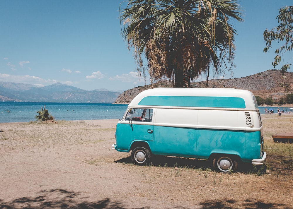 blue and white volkswagen t-2 parked on beach shore during daytime