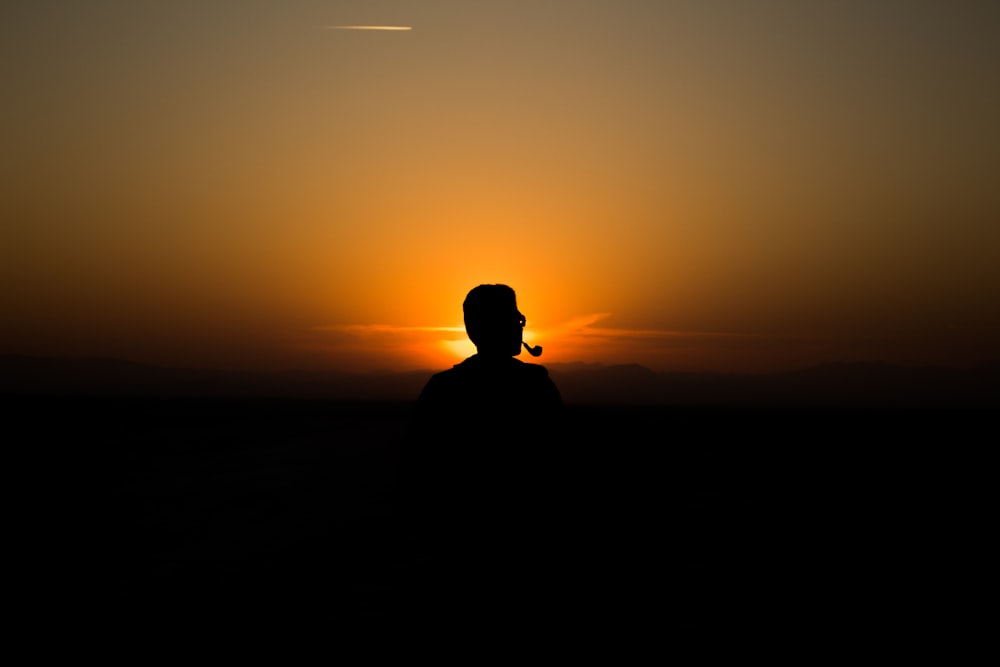 silhouette of man standing during sunset