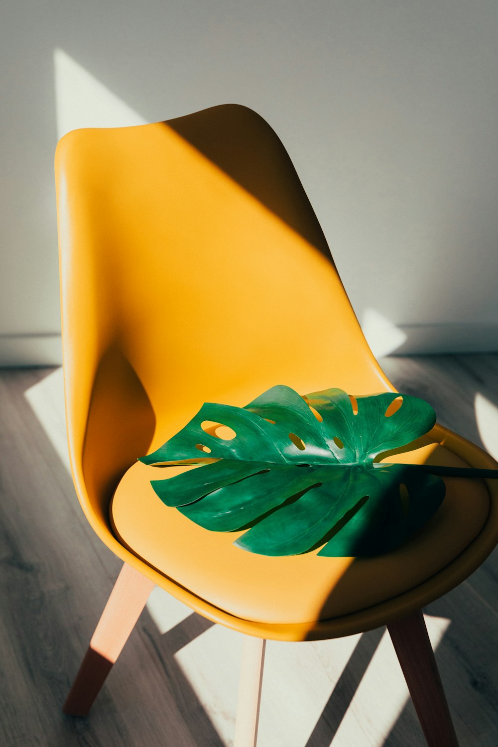 Grünes Blatt auf gelbem Stuhl