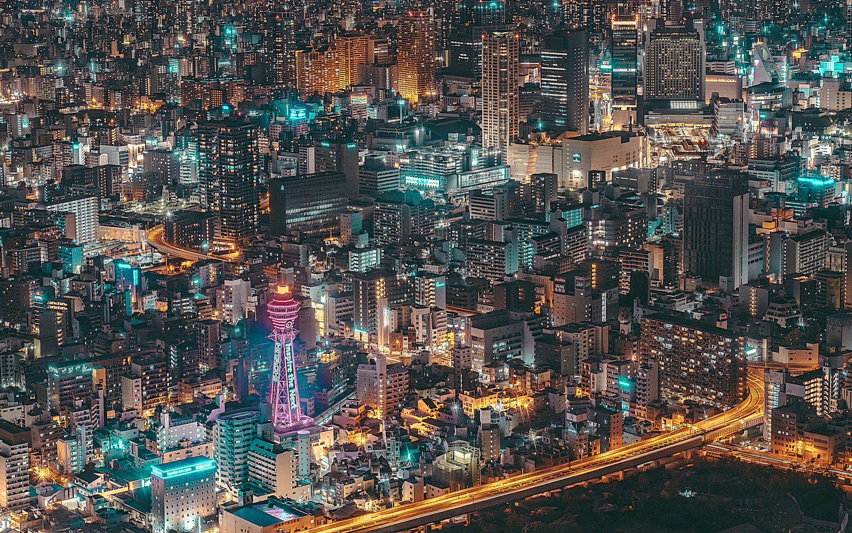 Osaka's dense city lights and Tsutenkaku seen from above at night