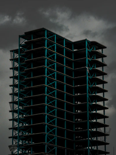An imposing steel framework rising against a moody sky, showcasing a commercial building mid-construction.