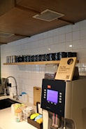 A stylish cafe kitchen featuring a coffee station.