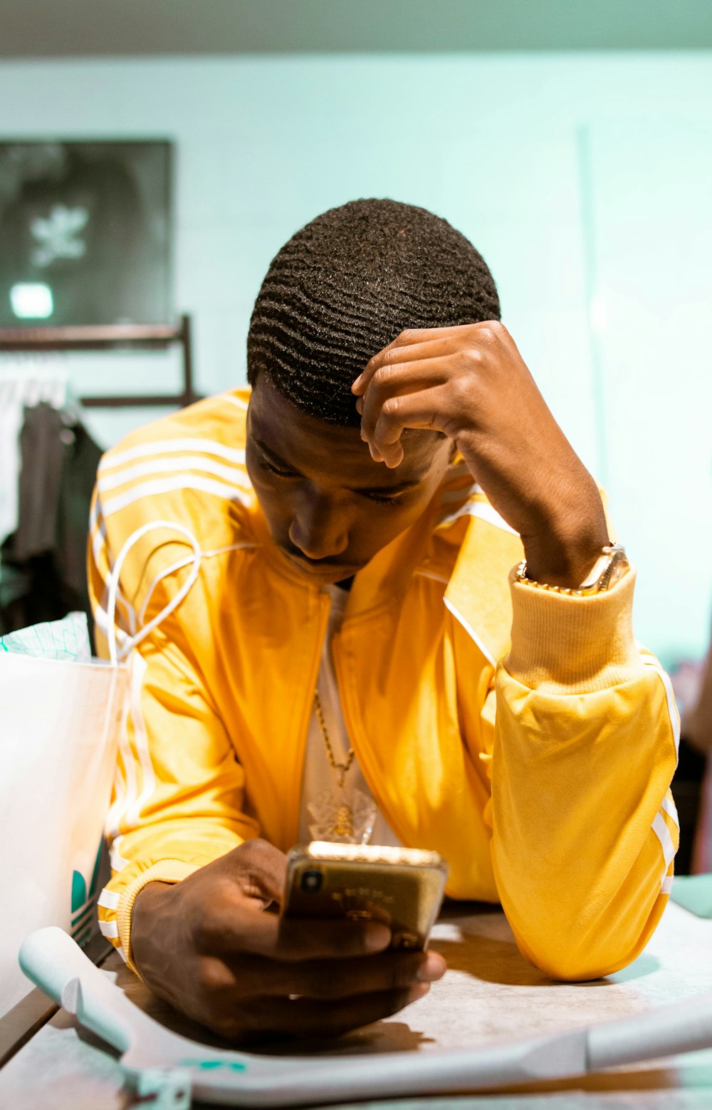 man in yellow dress shirt holding gold iphone 6