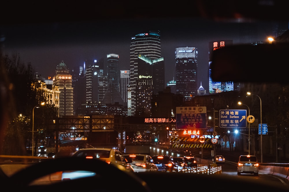 cars on road near high rise buildings during night time