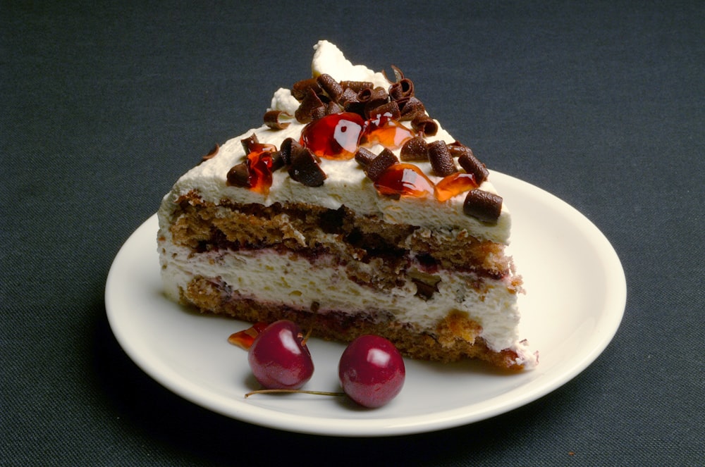 Bizcocho en rodajas con cereza sobre plato de cerámica blanca