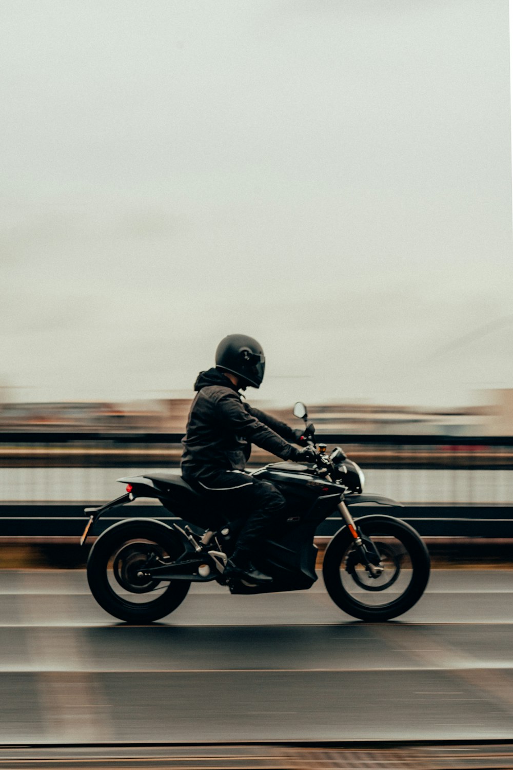 uomo in casco da motociclista nero in sella a moto