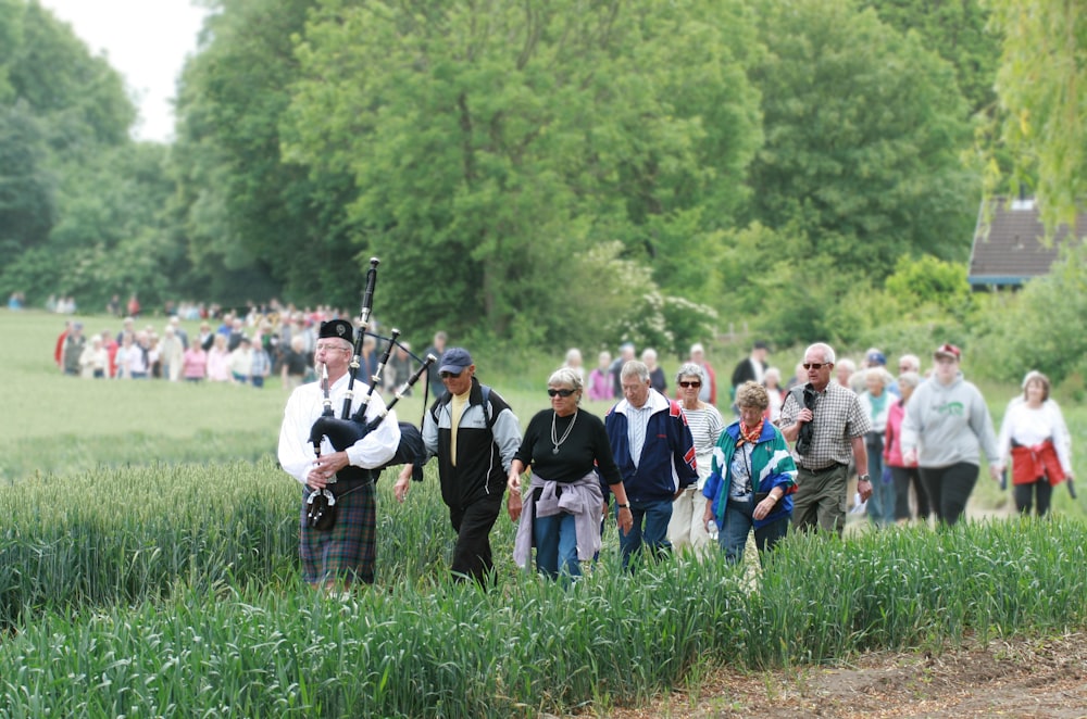 personas de pie en un campo de hierba verde durante el día