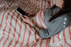 person in blue denim jeans lying on bed