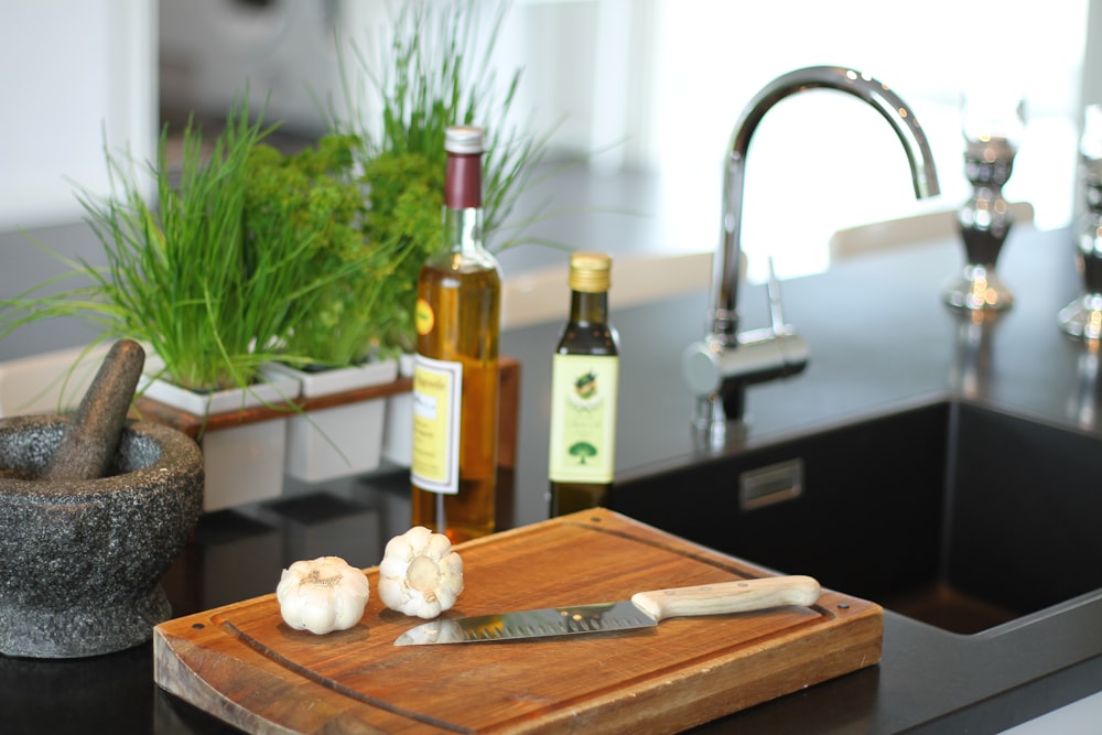 brown wooden chopping board with bread and bottle