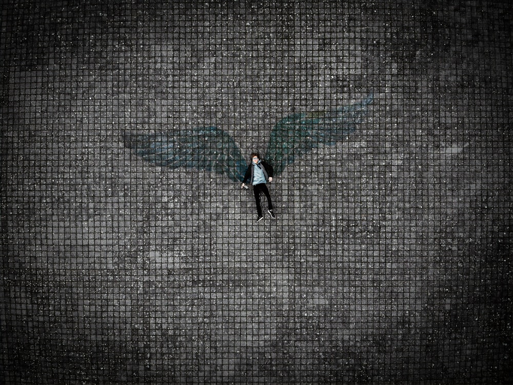 person in black pants walking on gray concrete pavement