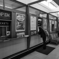 Close-up of hands exchanging event tickets at a booking counter.