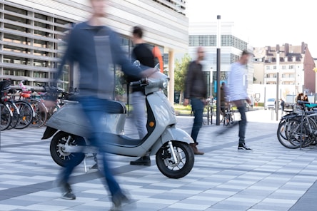 man in black suit riding on blue motor scooter
