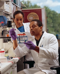 man in white chef uniform holding purple plastic blood test bottle