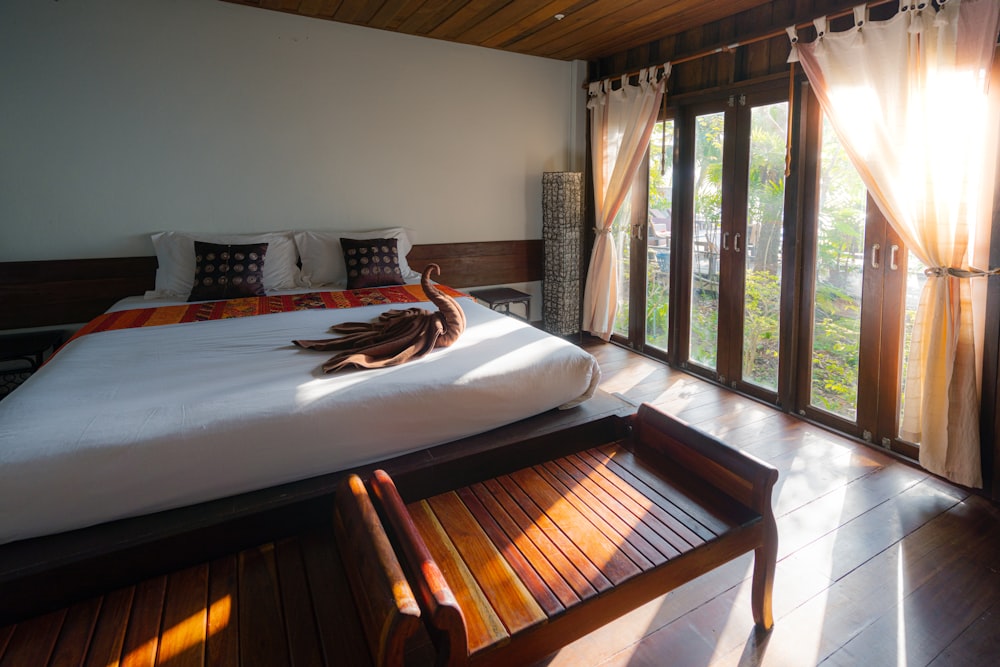 white bed linen with brown wooden bed frame