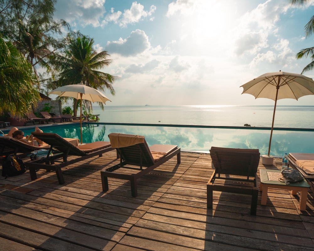 brown wooden lounge chairs on brown wooden dock during daytime