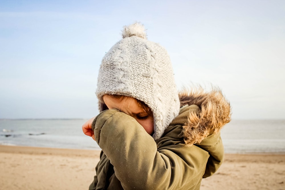 person in gray knit cap and gray jacket