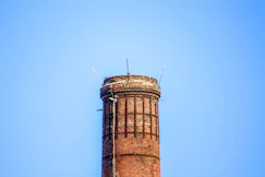 A beautifully repaired chimney standing tall against a clear blue sky.
