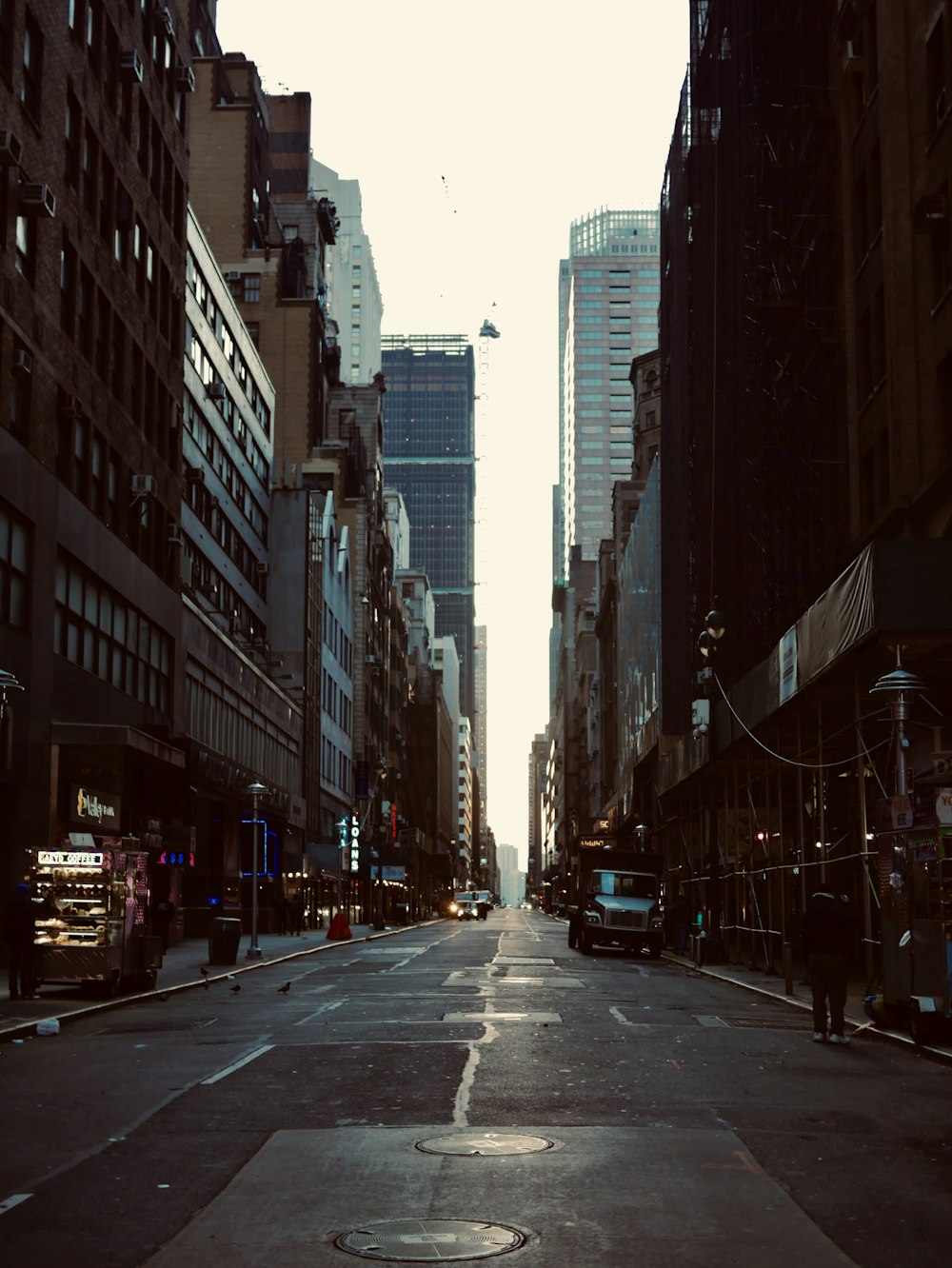 cars on road between high rise buildings during daytime