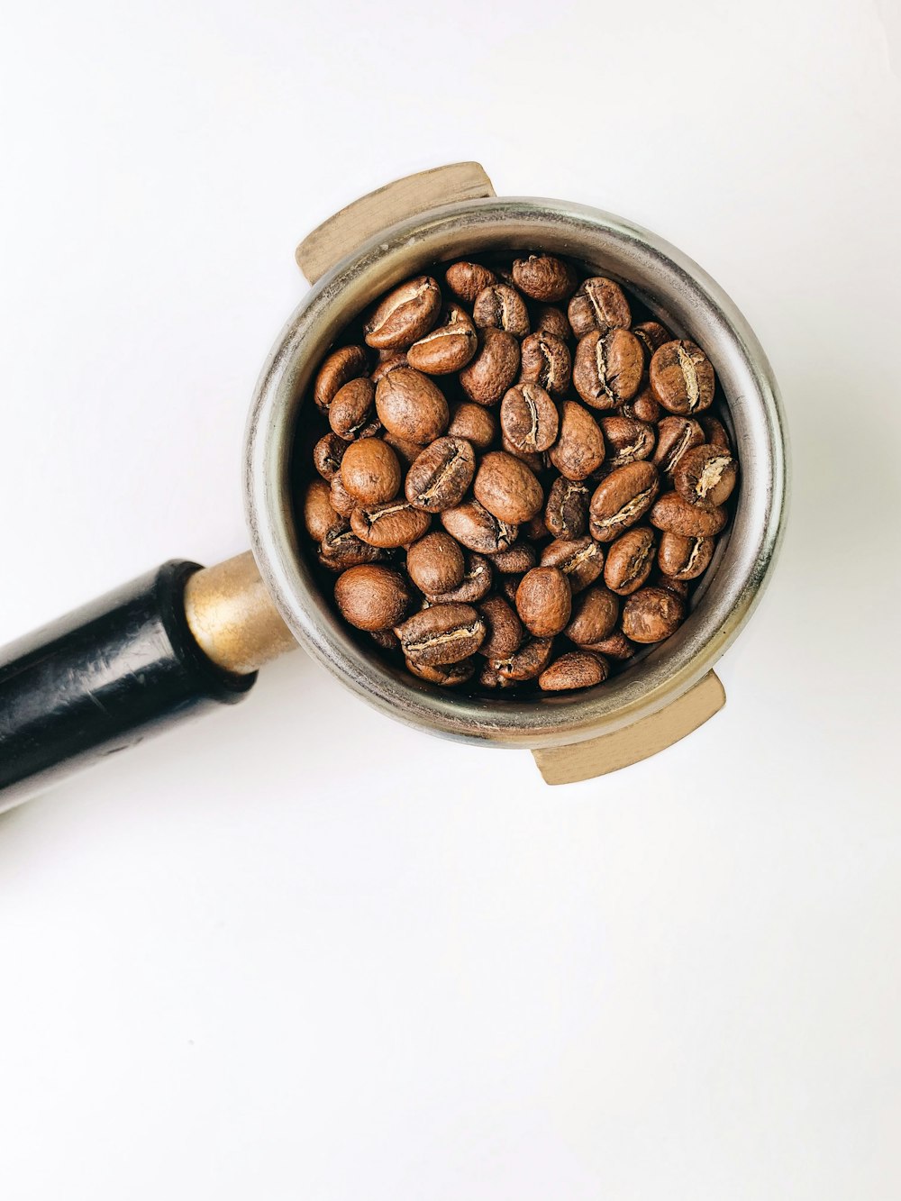 白いセラミックマグカップの茶色のコーヒー豆