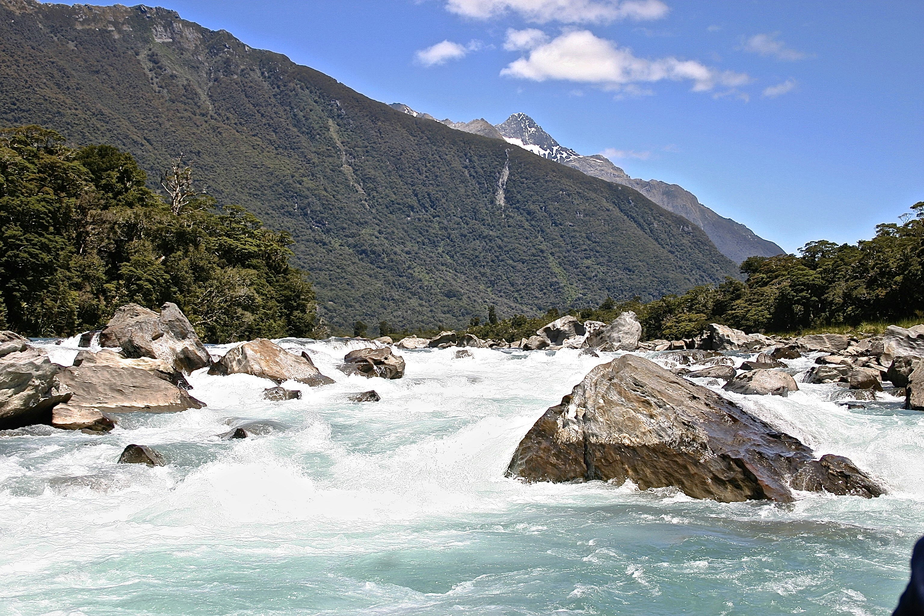 green mountain beside body of water during daytime, 