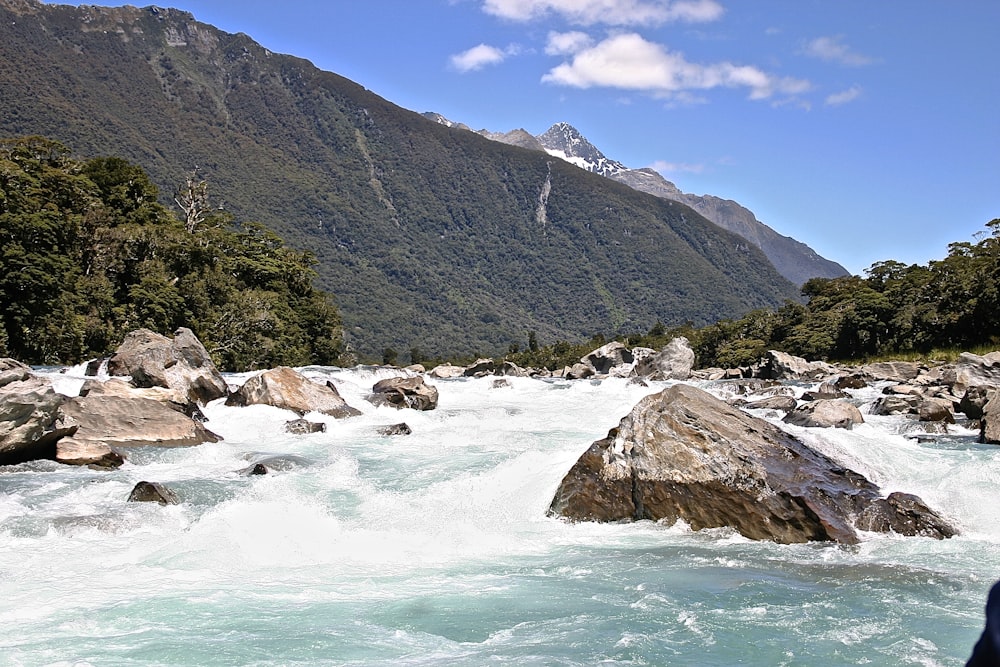 green mountain beside body of water during daytime