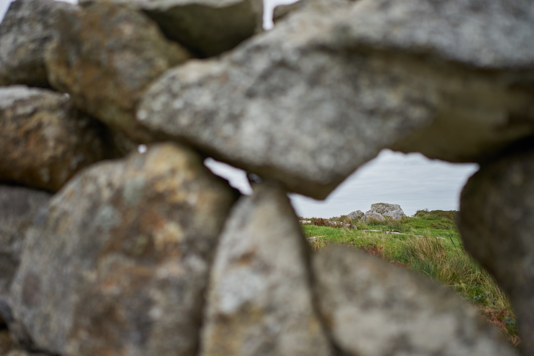 gray rock formation near green grass field during daytime