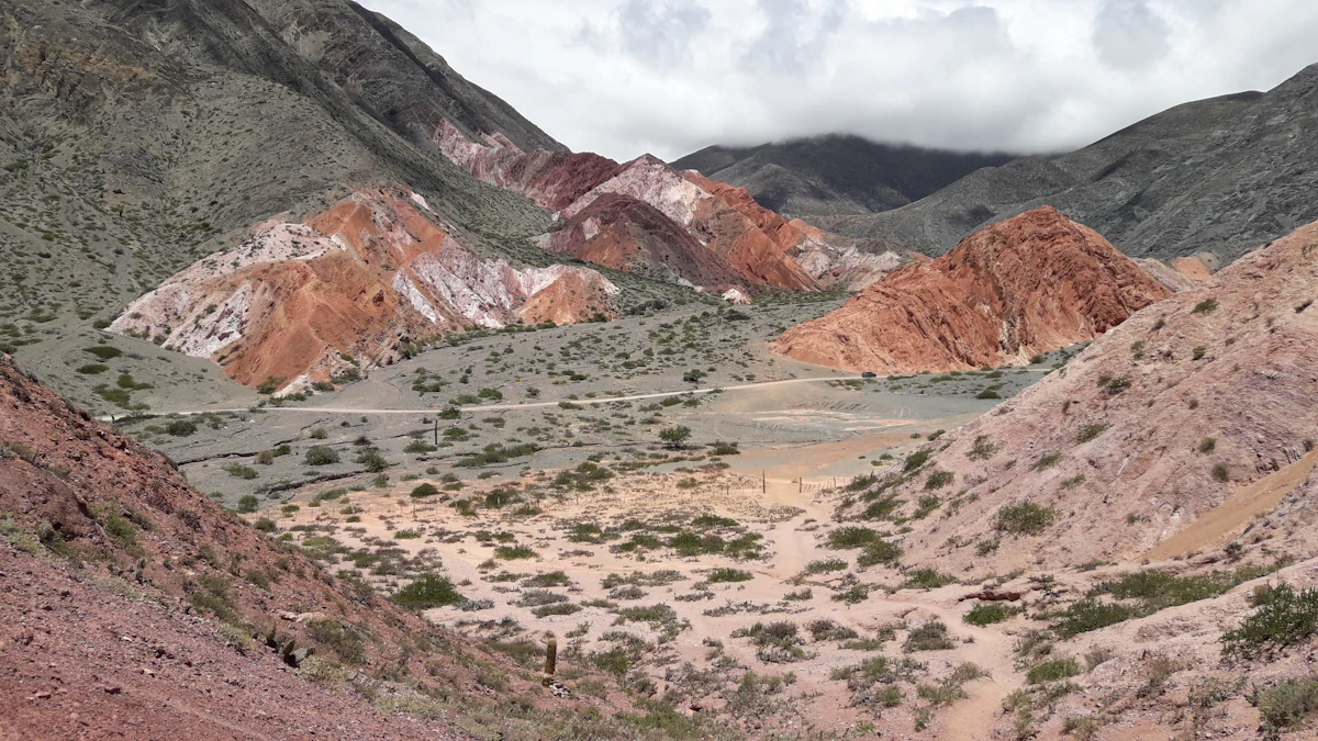 Red, white and green hills around a dry, scrubby valley near Purmamarca