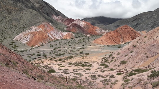 brown and gray mountains under white sky during daytime in Purmamarca Argentina